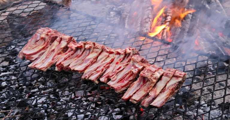 Beef short ribs glazed with rich sauce, garnished with herbs on a rustic serving plate